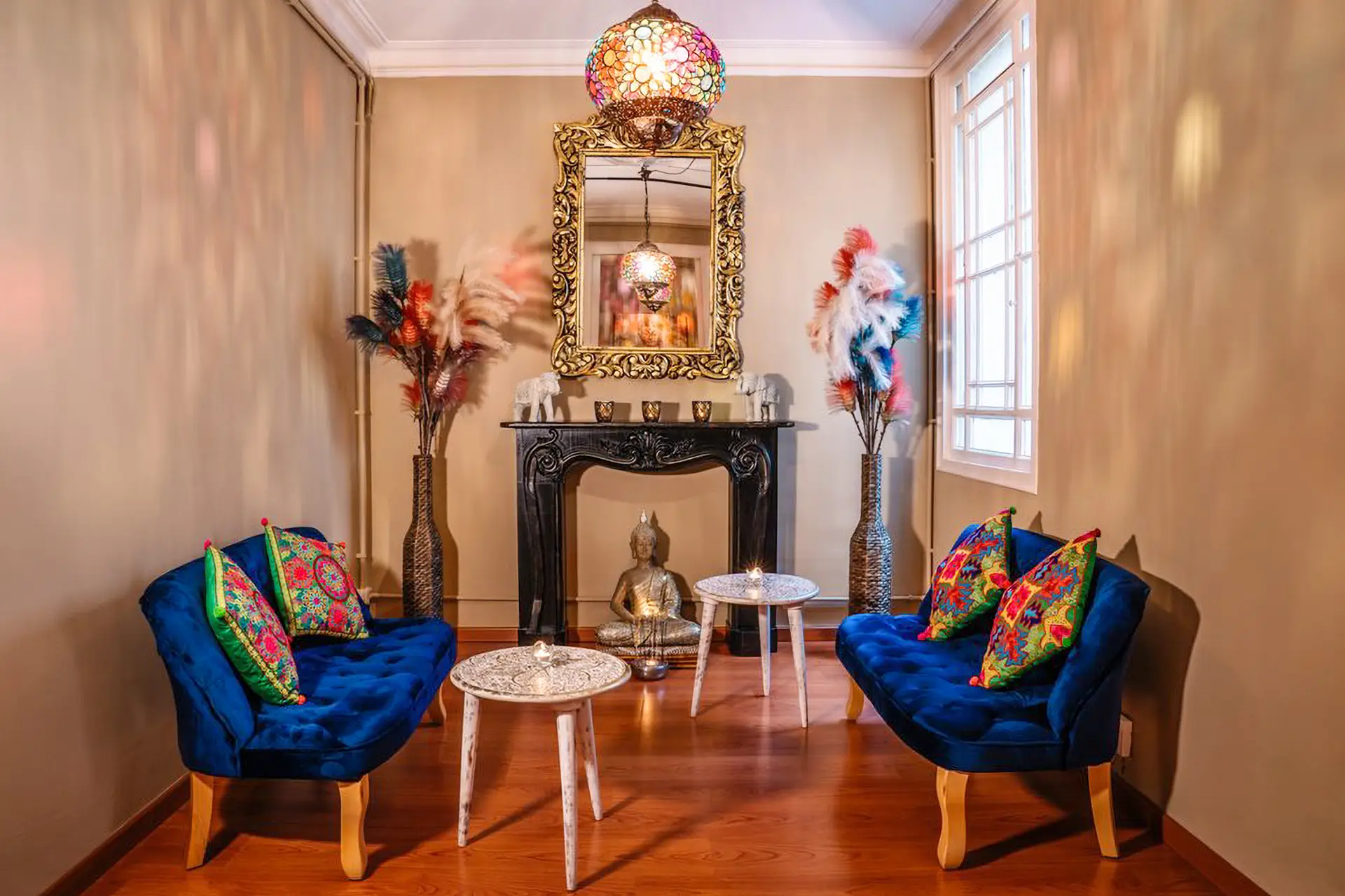 Sala de espera con butacas azules, espejo dorado y Buda