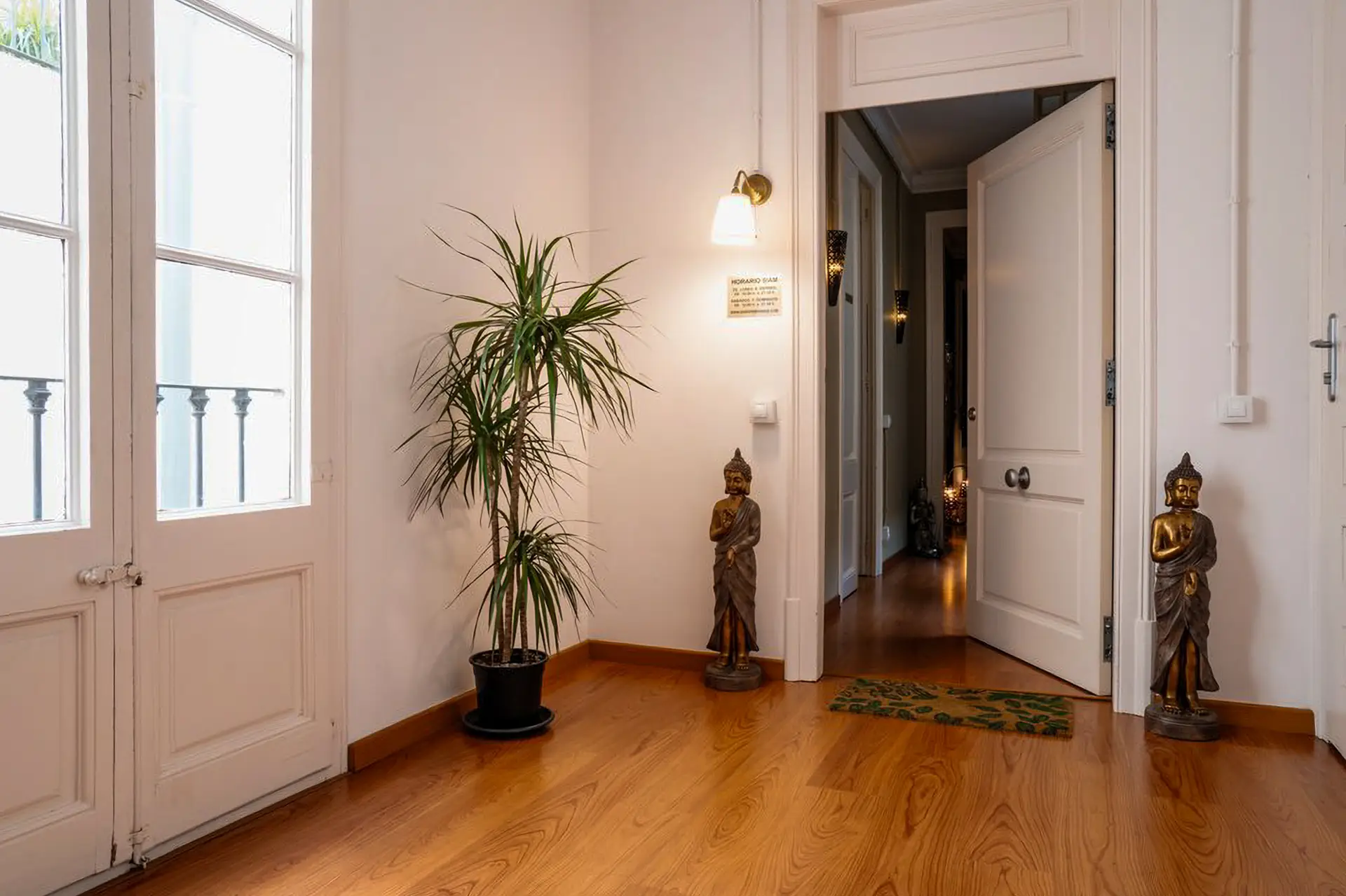 Entrada del centro con puerta abierta, planta y estatuas de Buda